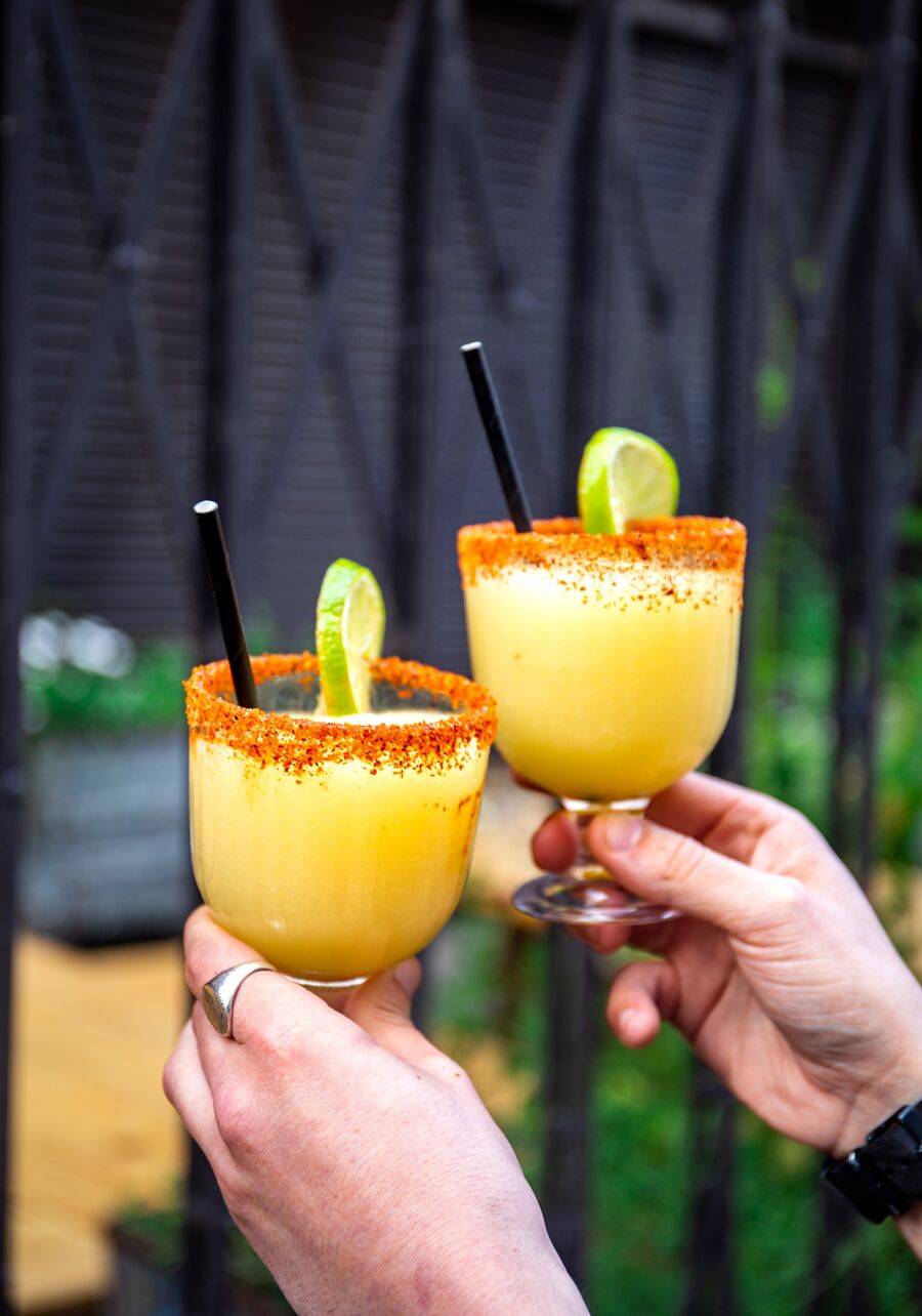 Two frozen margaritas clinking in a cheers